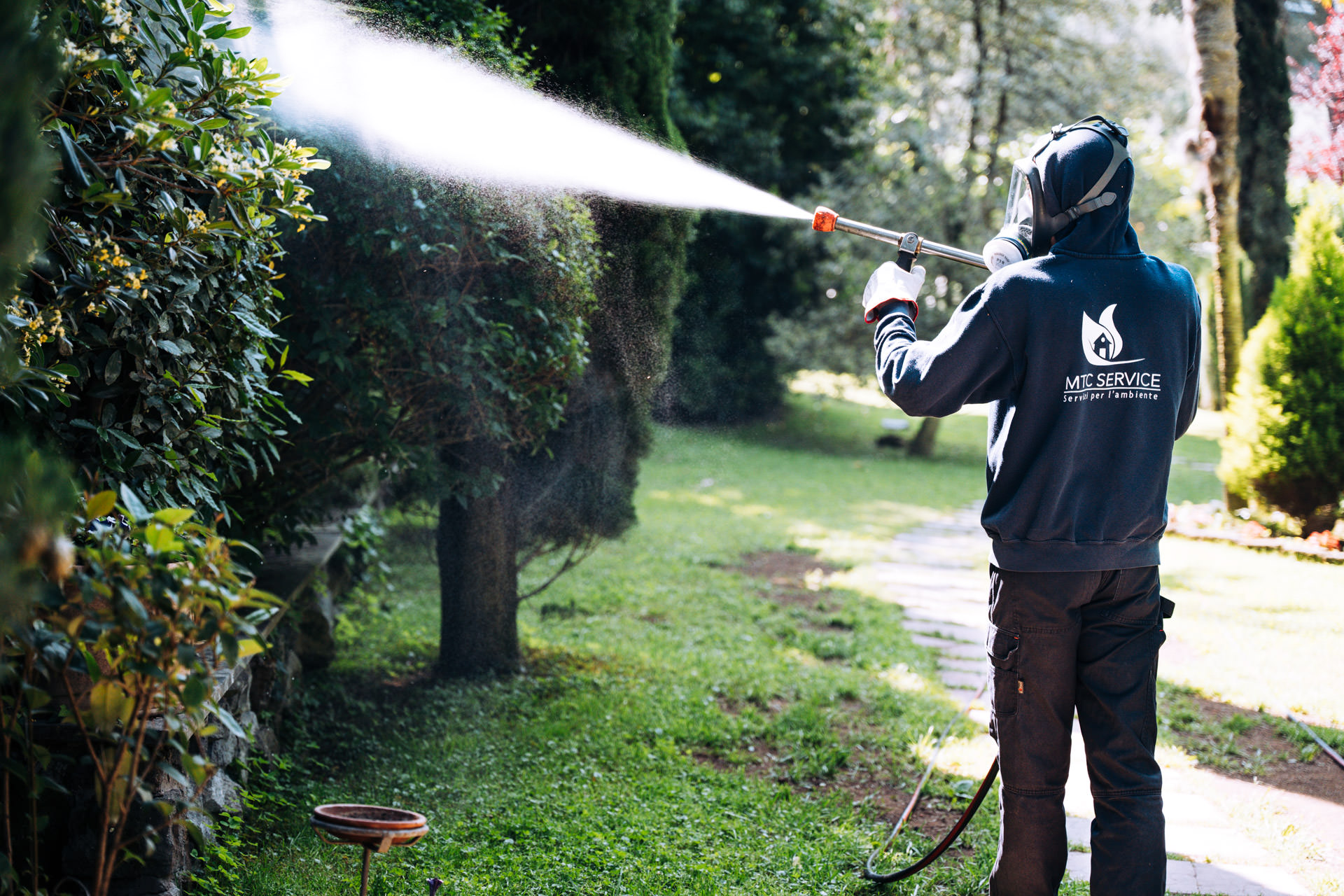 Operatore MTC Service esegue un trattamento professionale contro le zanzare in giardino